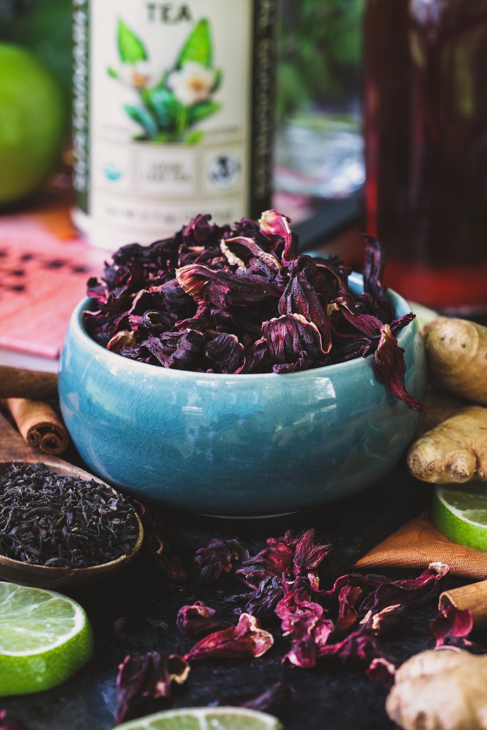 A small bowl with dried hibiscus flowers and black tea beside it