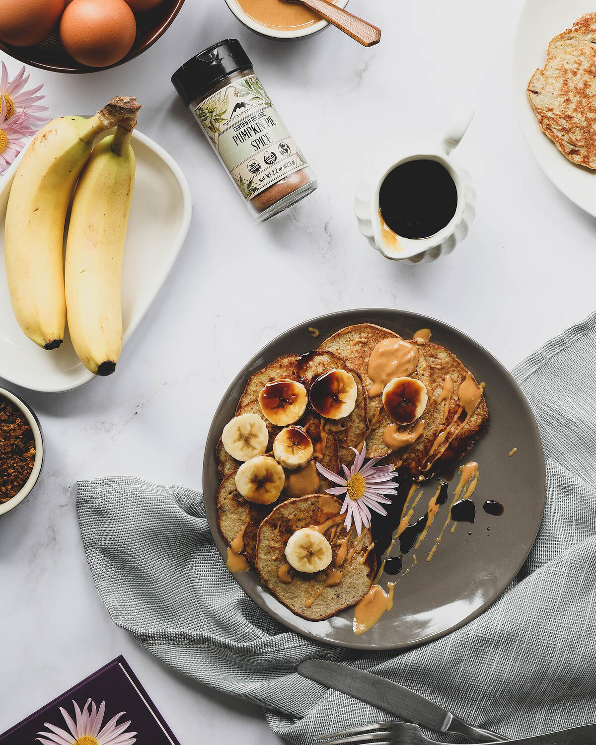 Banana Pancakes on a plate with sliced bananas and chaga maple syrup
