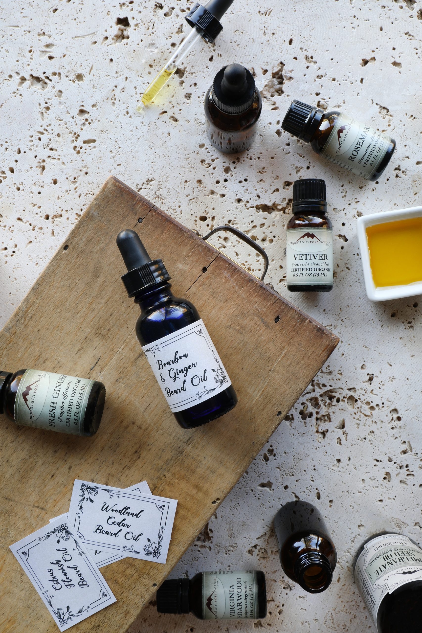 Displayed essential oils bottles and homemade beard oil bottle with dropper top.