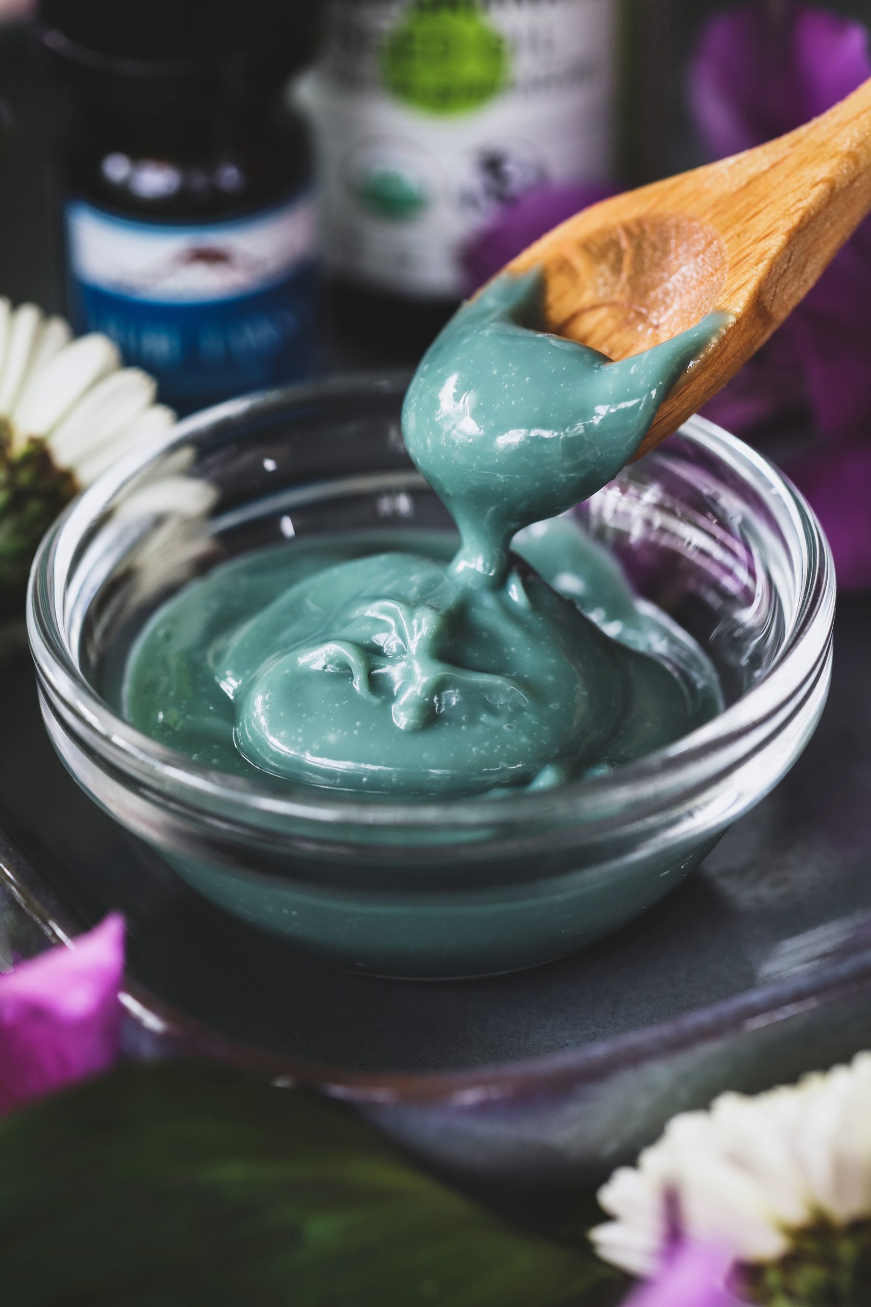 A close up shot of cleanser cream getting scooped up by small spoon