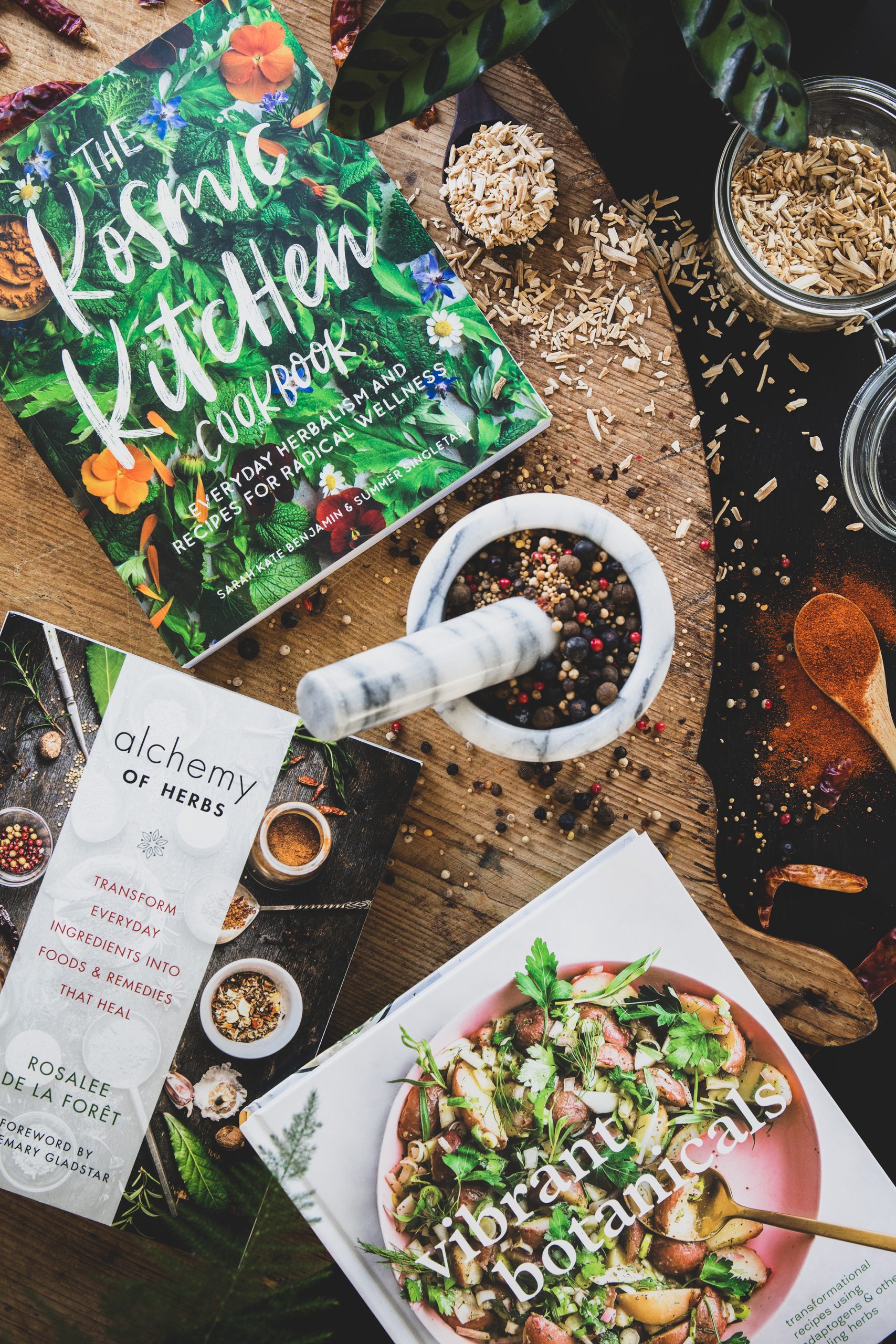 Three favorite books on natural cooking with herb filled mortar and pestle. 