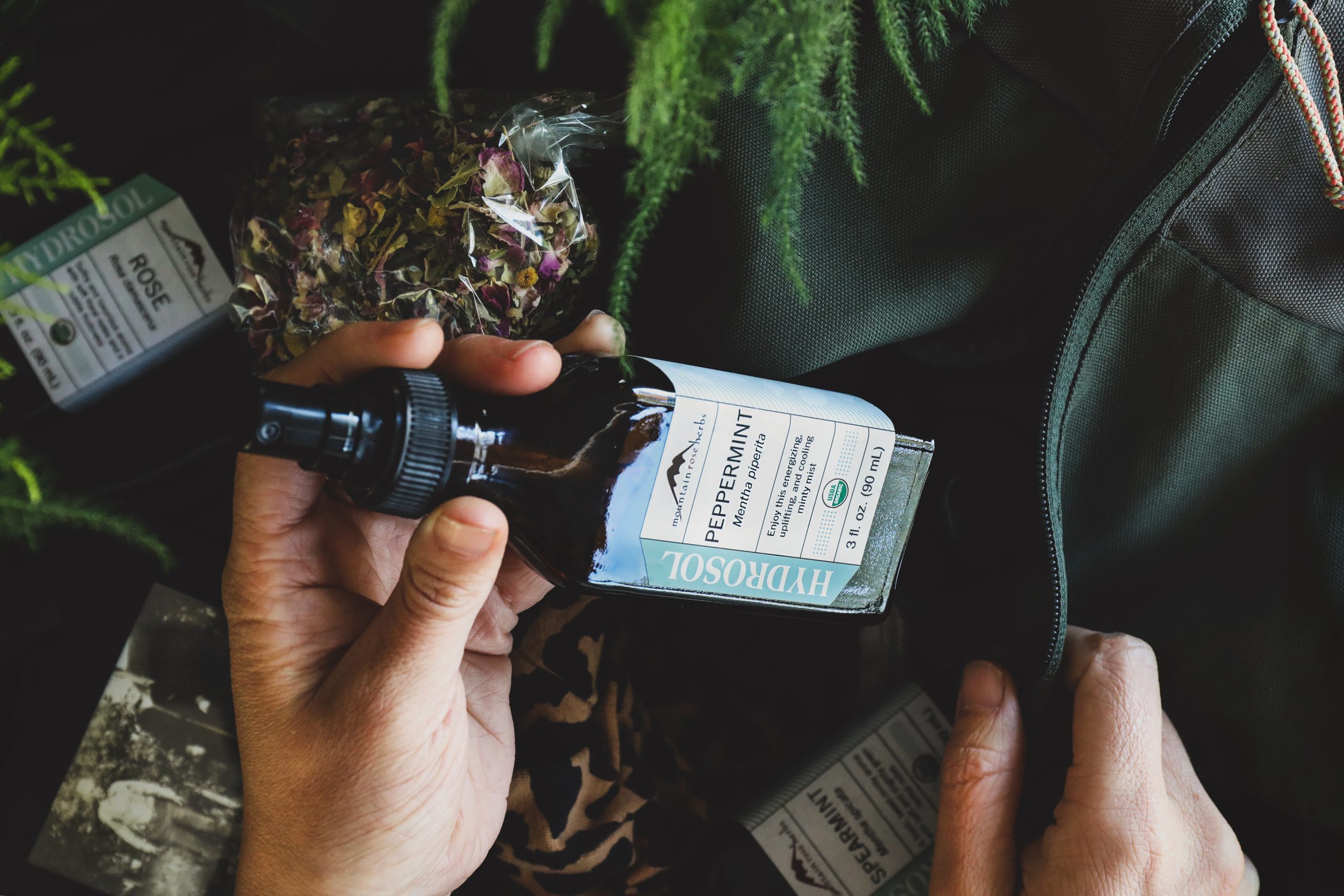 Bottle of peppermint hydrosol being put into bag.