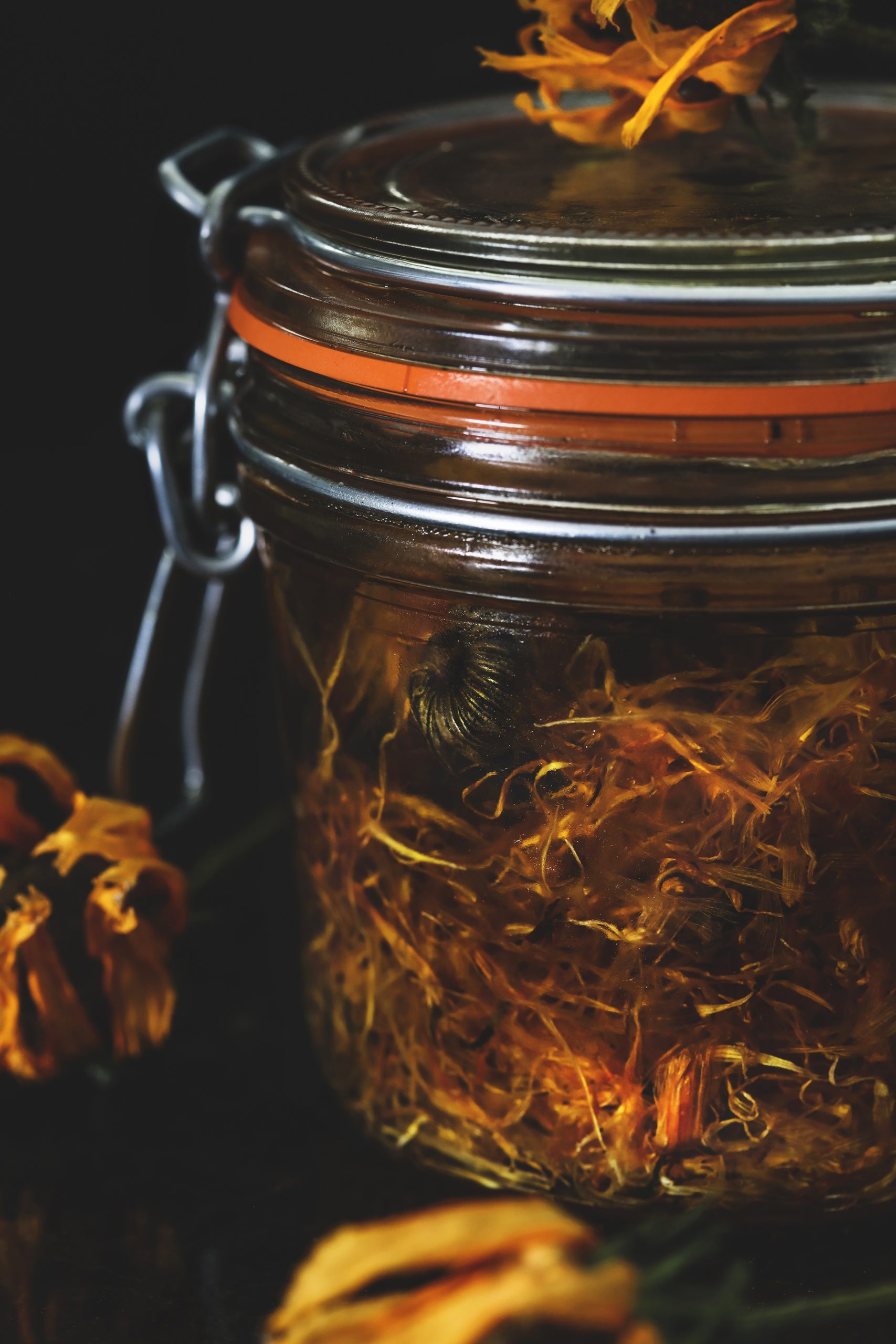 Jar of calendula herbal oil being made.