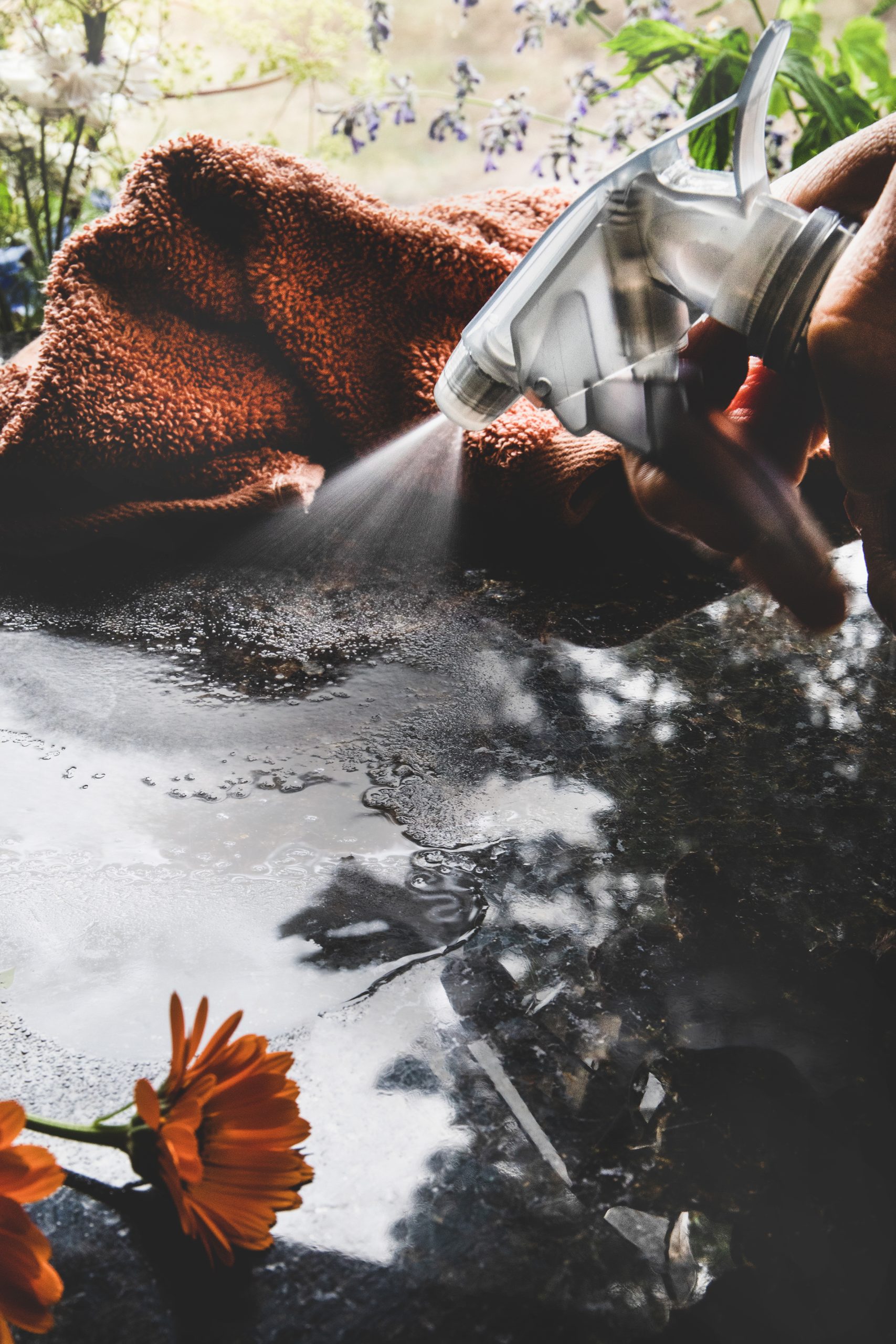granite cleaner with essential oils spraying onto surface.