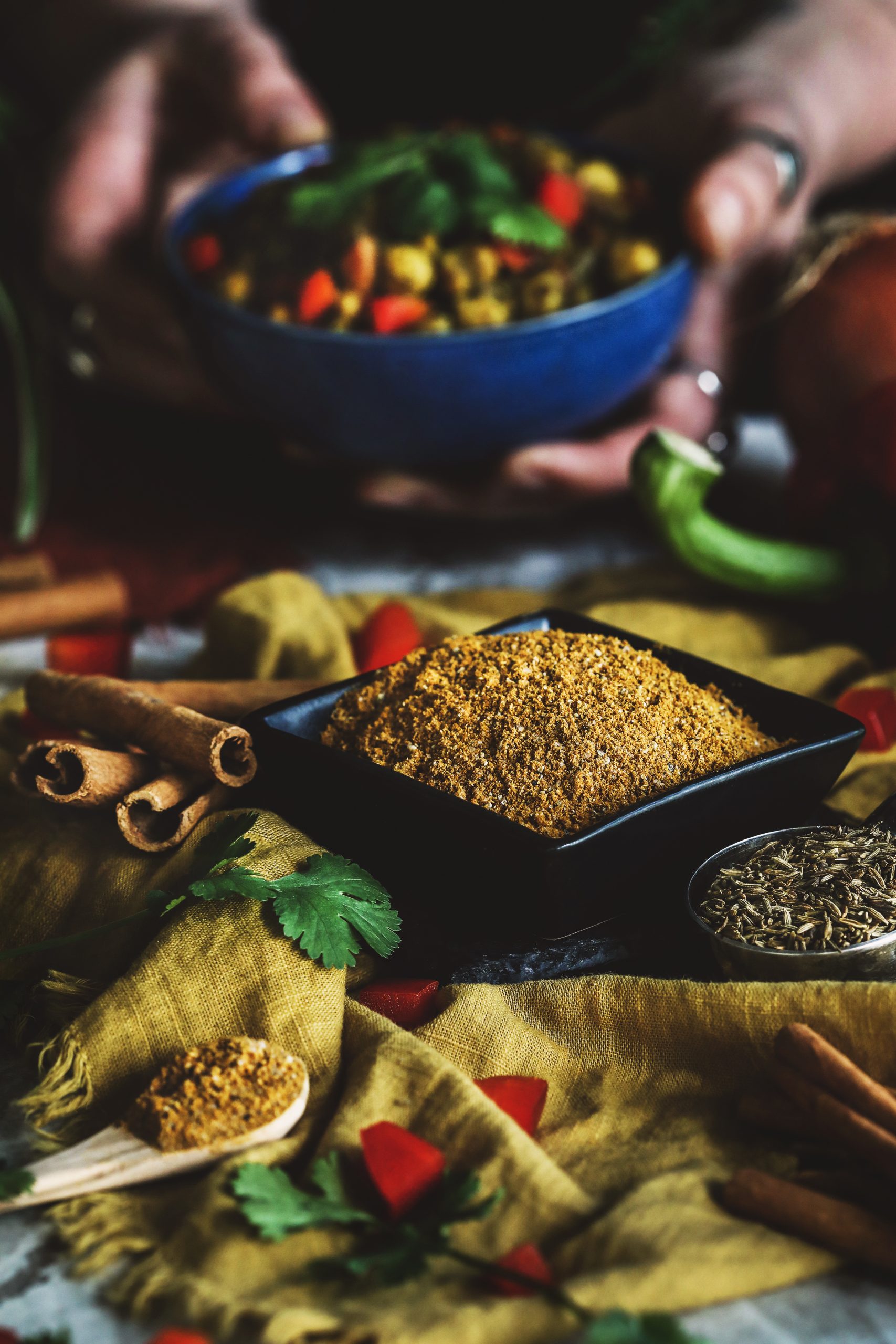 Cumin punjabi spice blend with a bowl of curry in the background