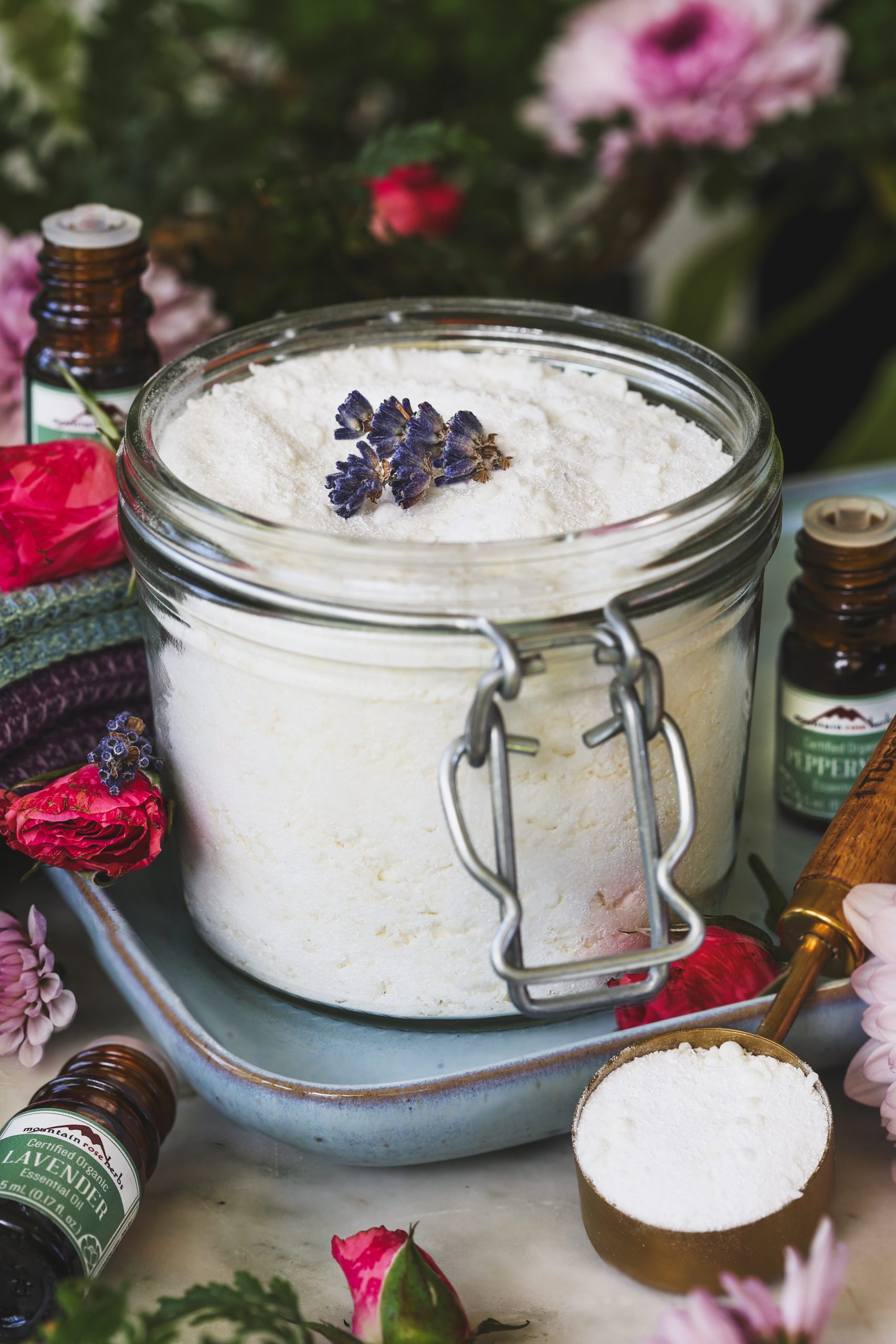 A jar of homemade laundry detergent with lavender essential oil next to it