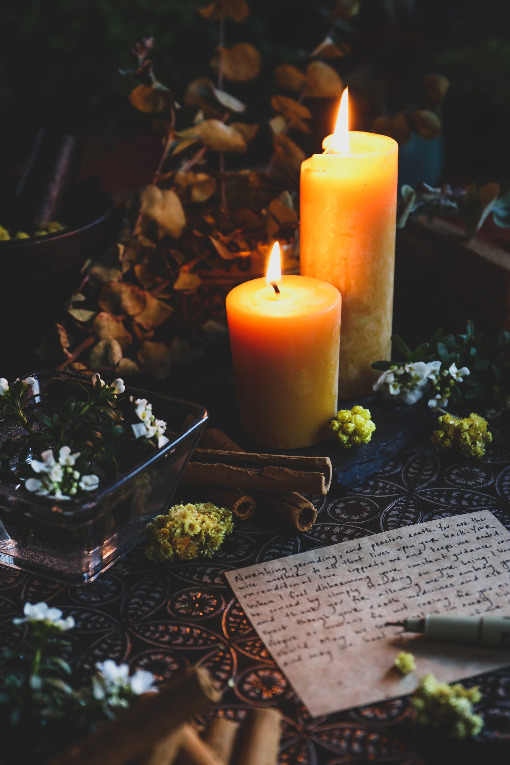 Burning candles to set intentions surrounded by herbs used by a curandera