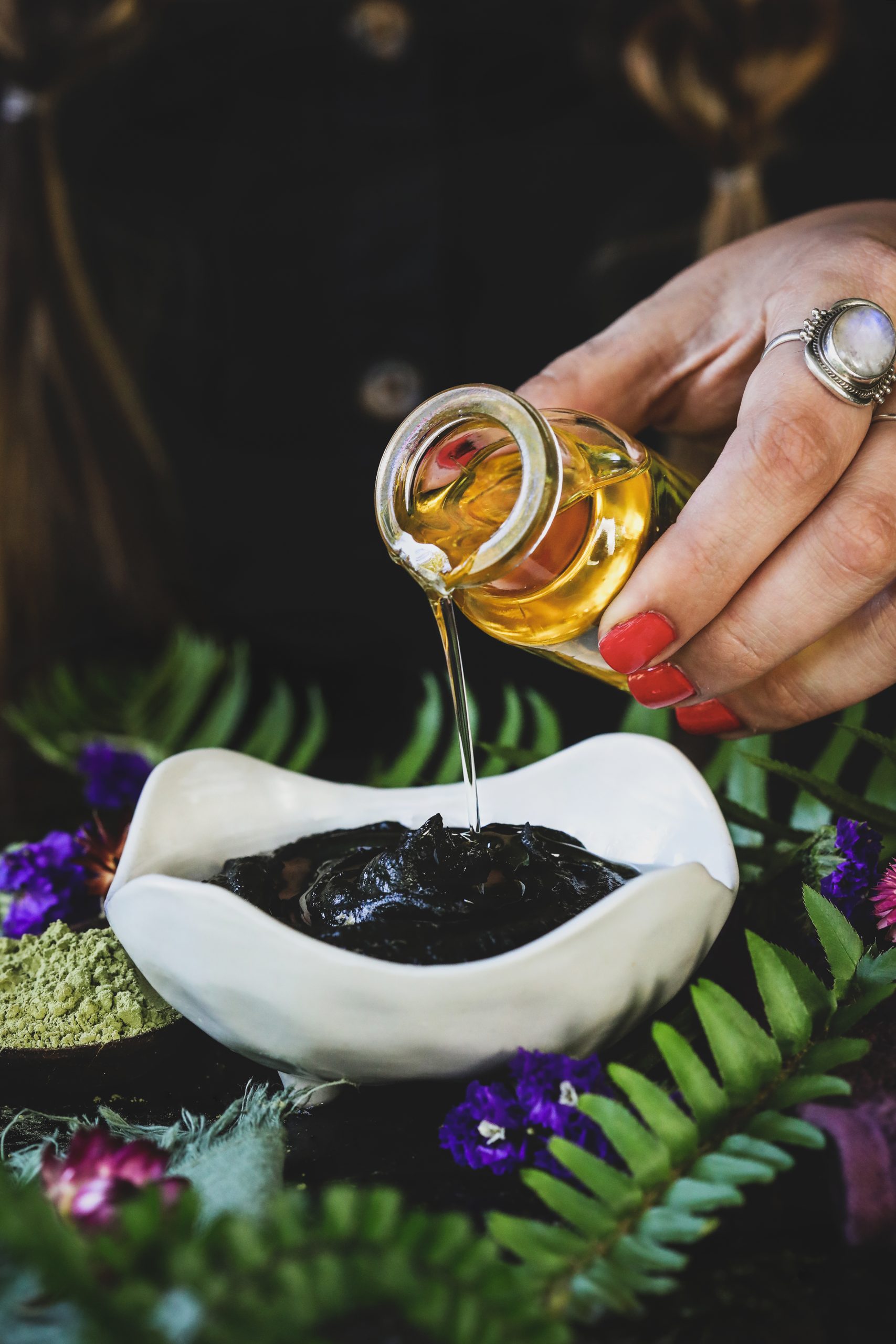 Jojoba oil is poured into henna for extra nourishment