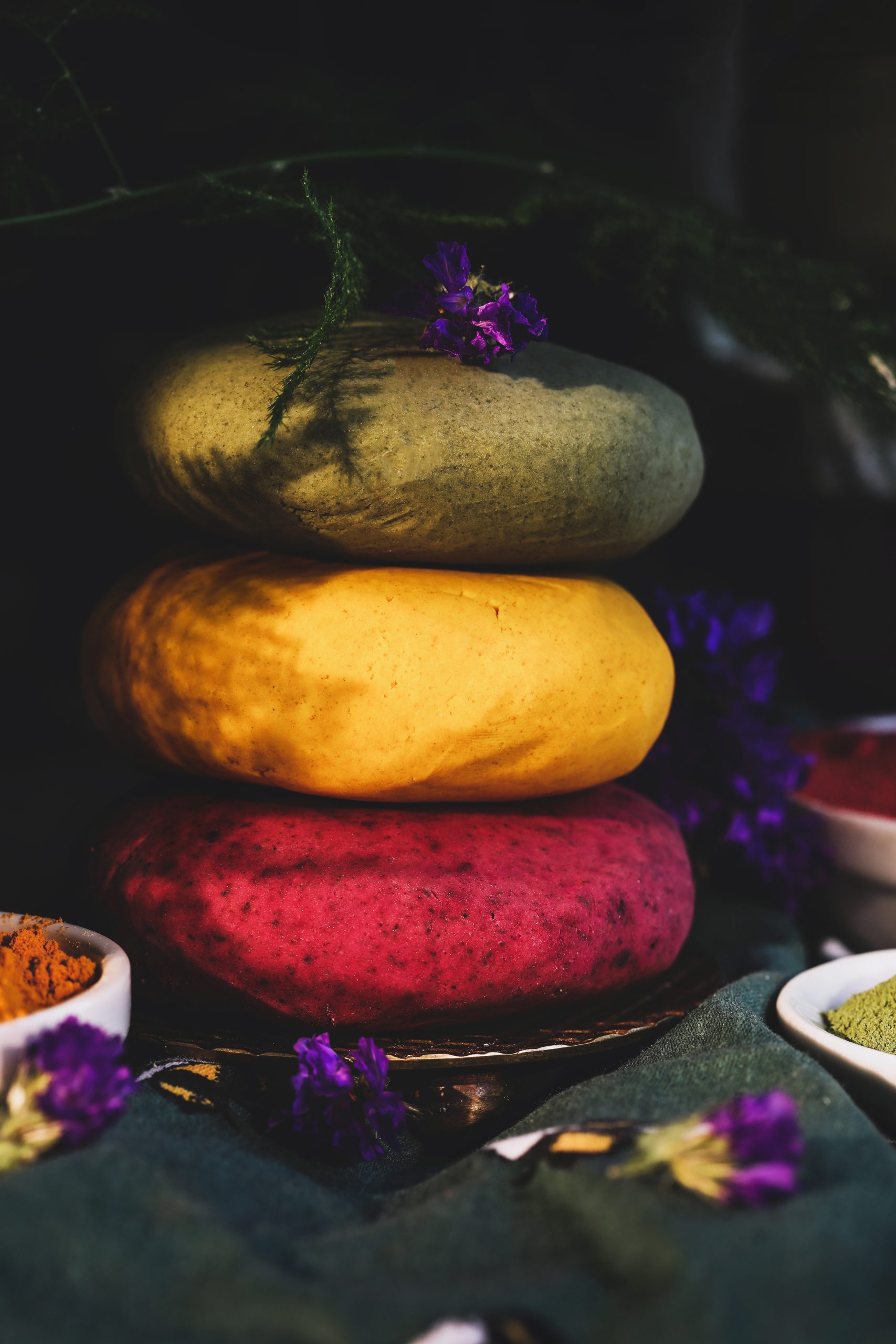 Multicolored stack of homemade playdough colored with herbal powders.