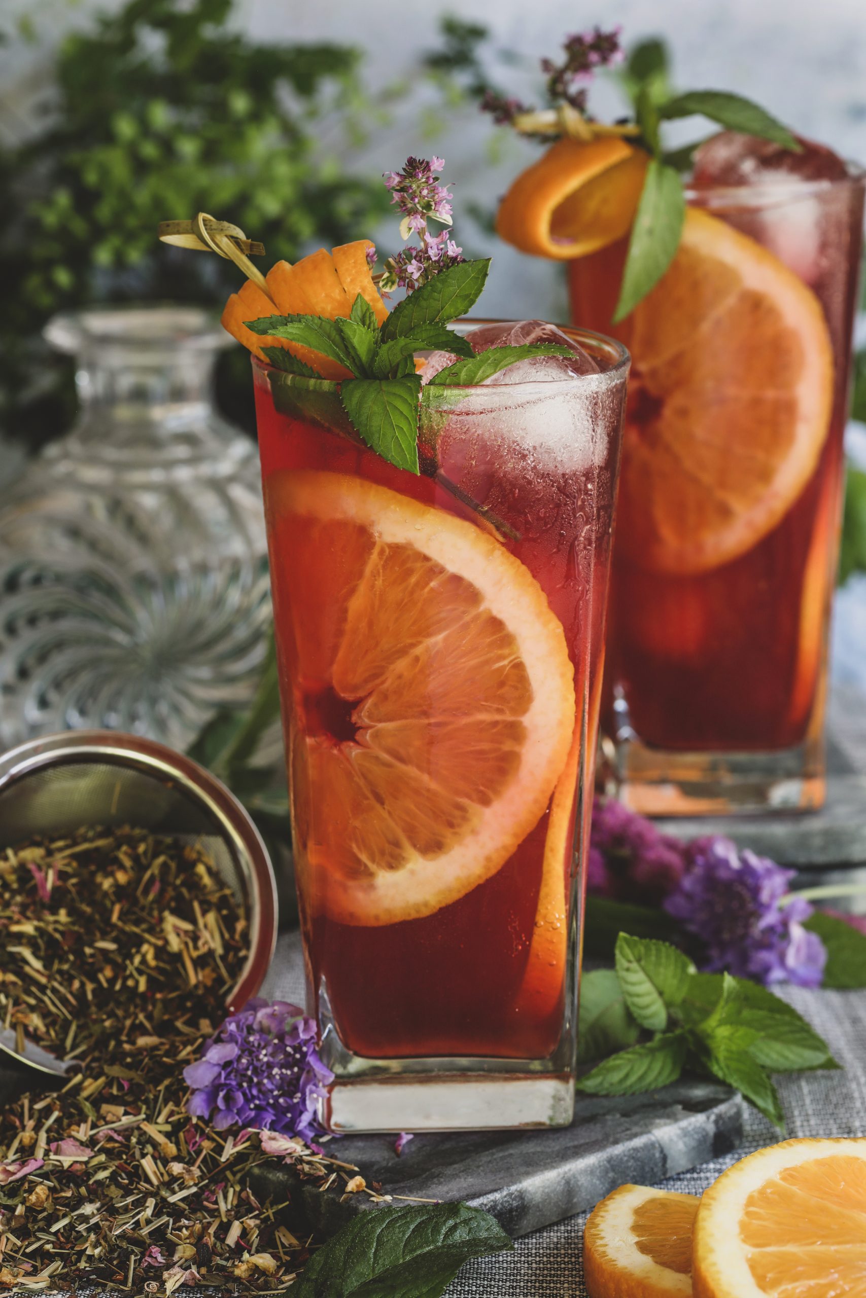Summer Herbal Highballs in tall glasses garnished with mint and orange slices.
