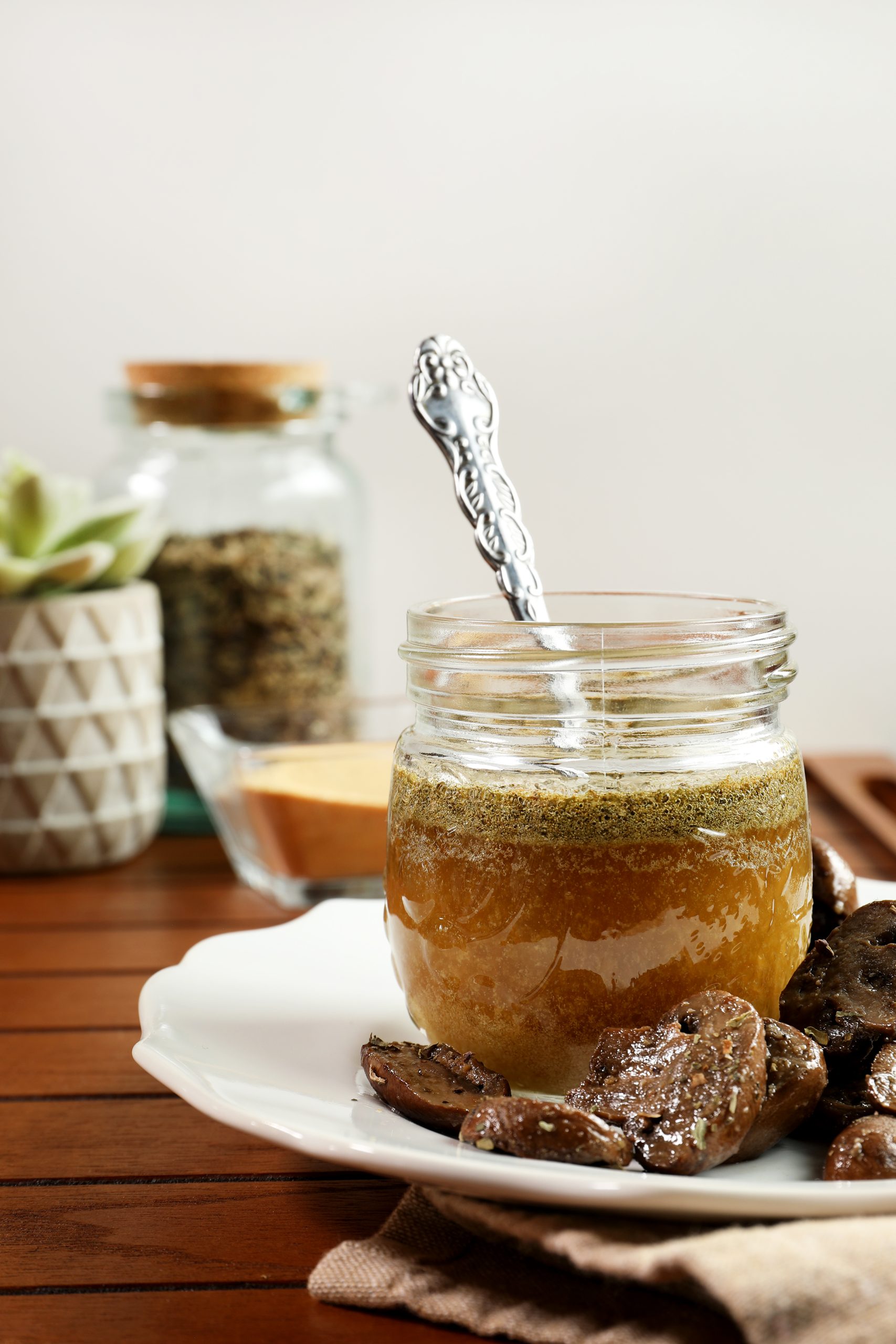 Italian herb and garlic ghee in glass jar with spoon.