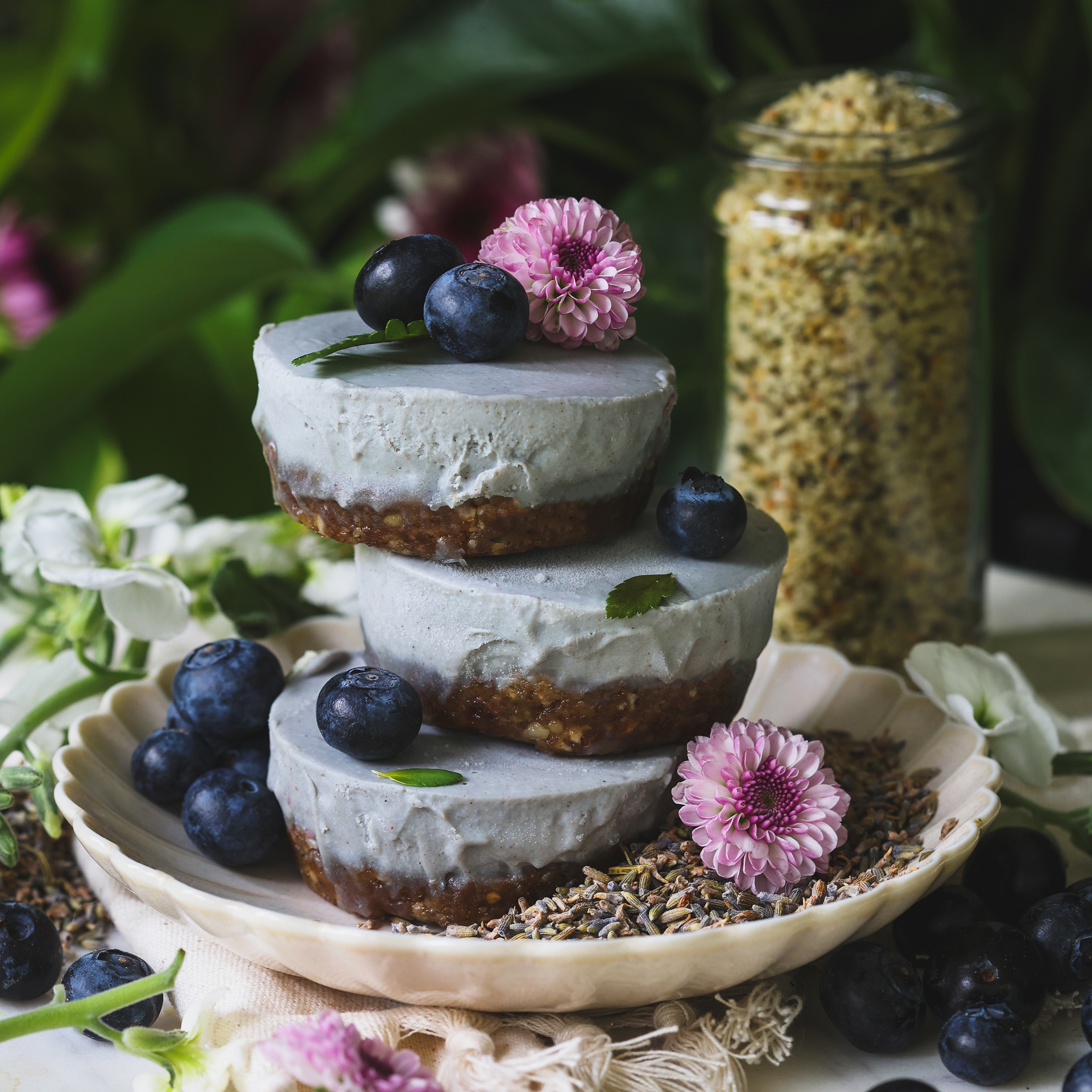 A stack of three lavender cheesecakes topped with blueberries