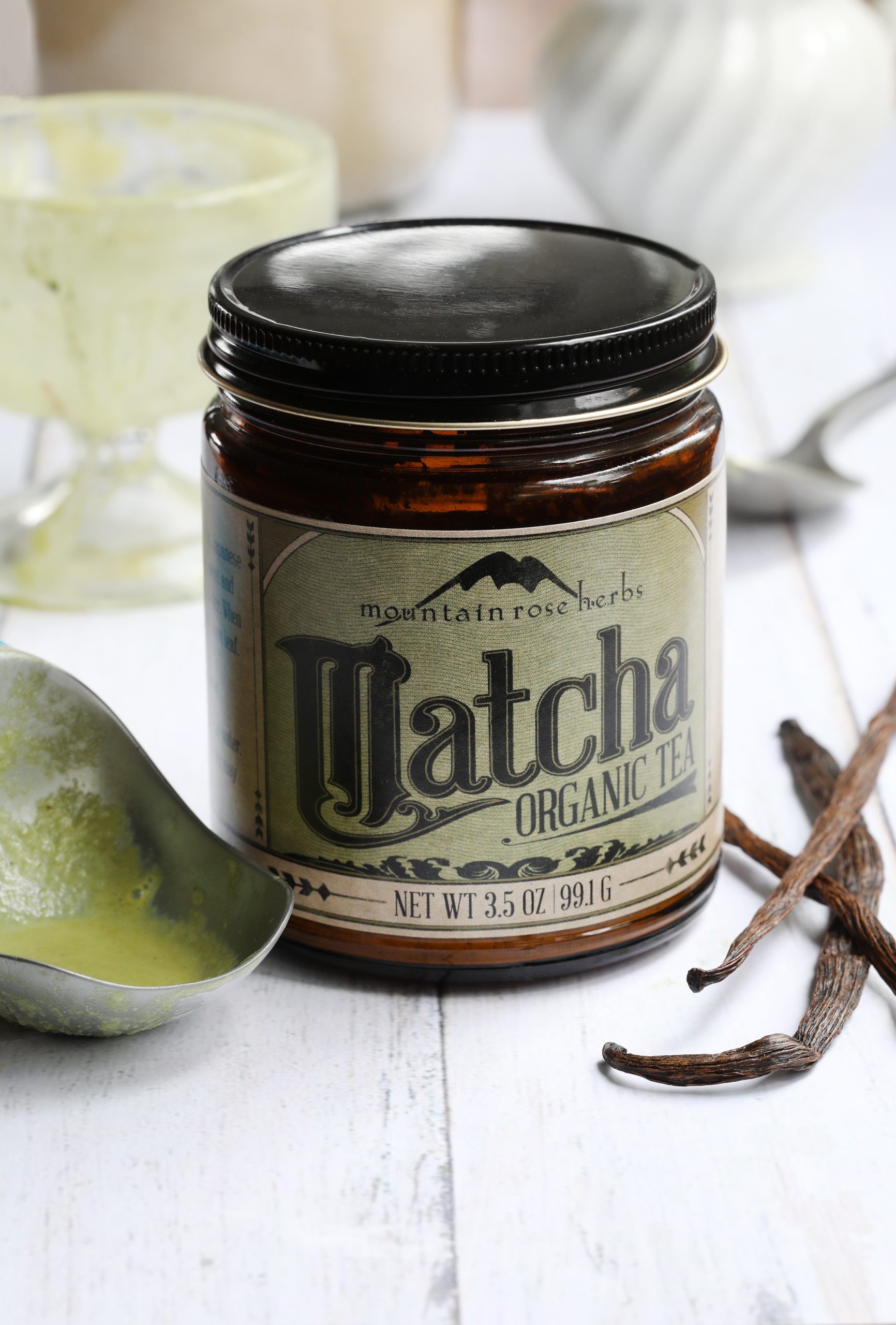 Jar of Mountain Rose Herbs Matcha powder laying next to vanilla beans