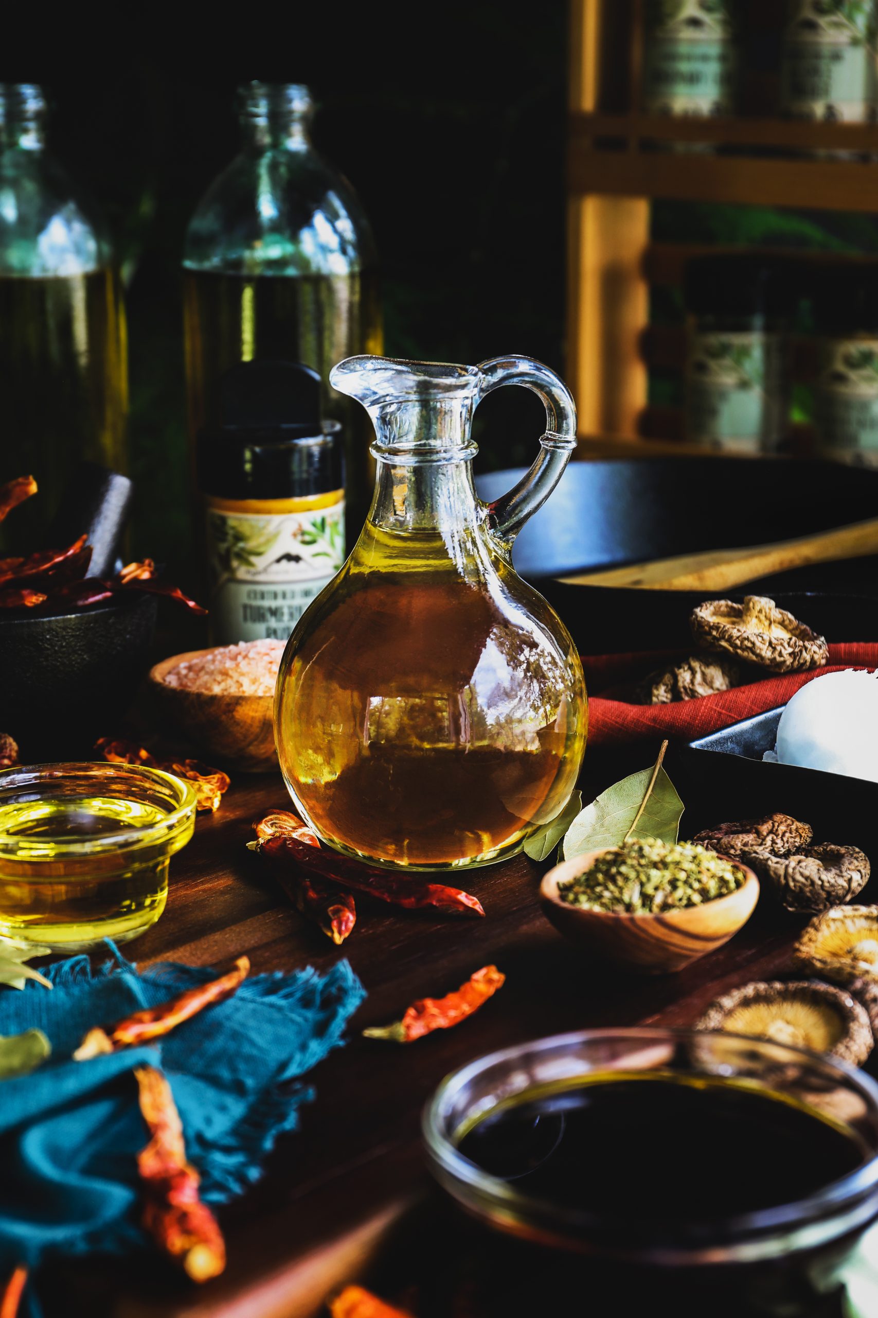 Bottle of cooking oil surrounded by herbs