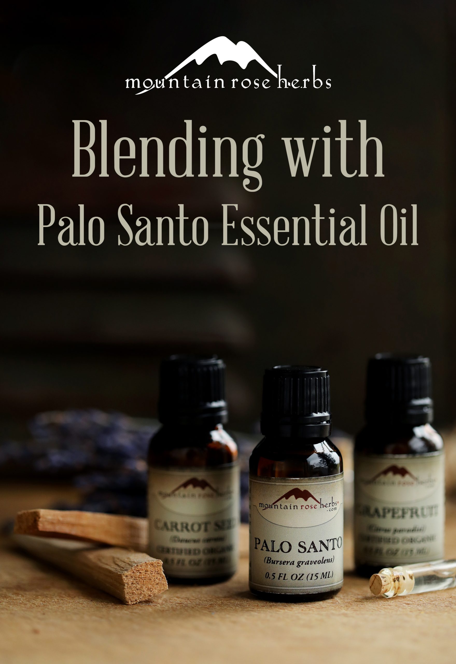 Essential oil bottles arranged with lavender, palo santo sticks, and a dark background. 