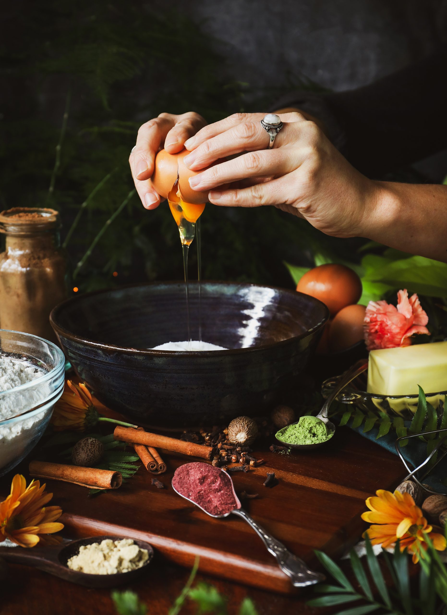 An egg is cracked into a bowl of ingredients