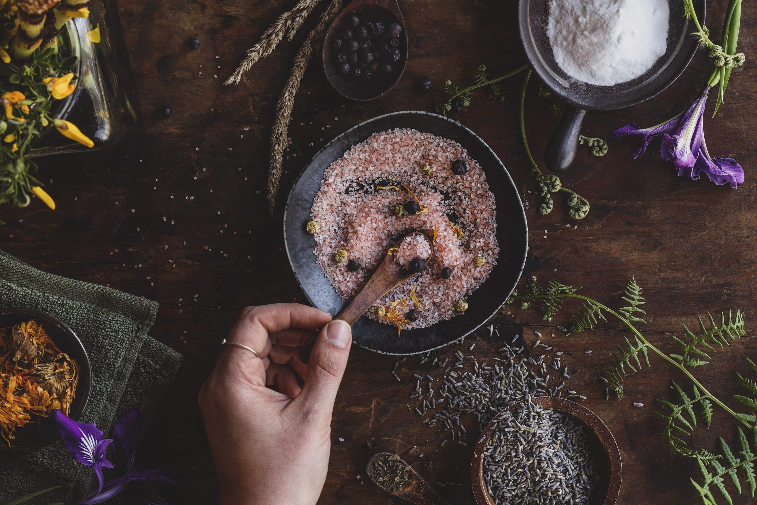 Preparing herb-infused salts in a bowl for a DIY sitz bath