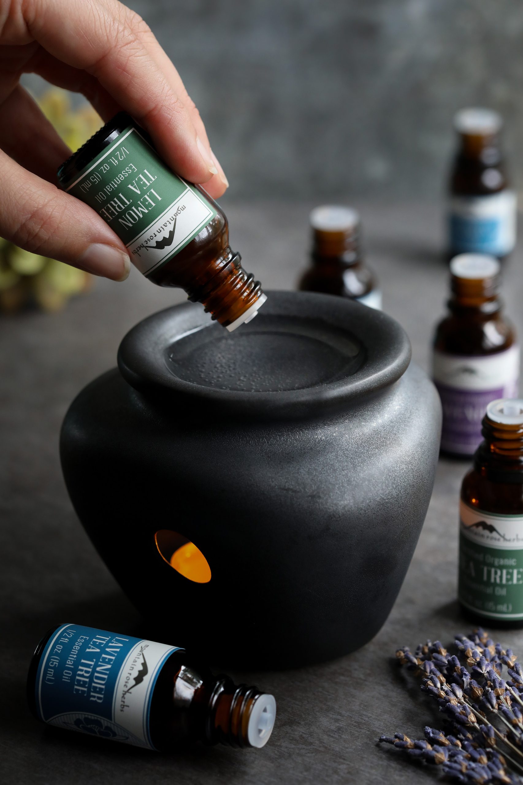 Using a ceramic essential oil diffuser, organic lemon tea tree oil is blended with water and then heated with a tea light to disperse aromatherapy throughout a home or office space.