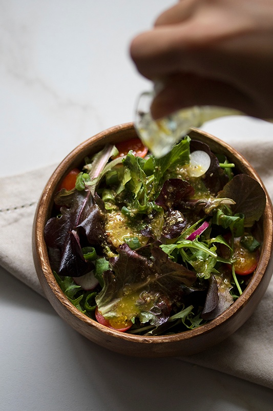 Vinaigrette pouring onto green salad Vinaigrette pouring onto green salad
