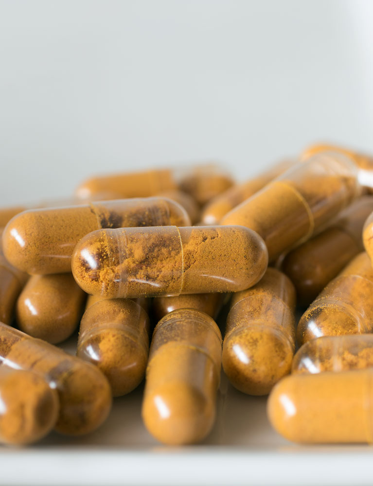 Capsules of turmeric made with the capsule machine on white background