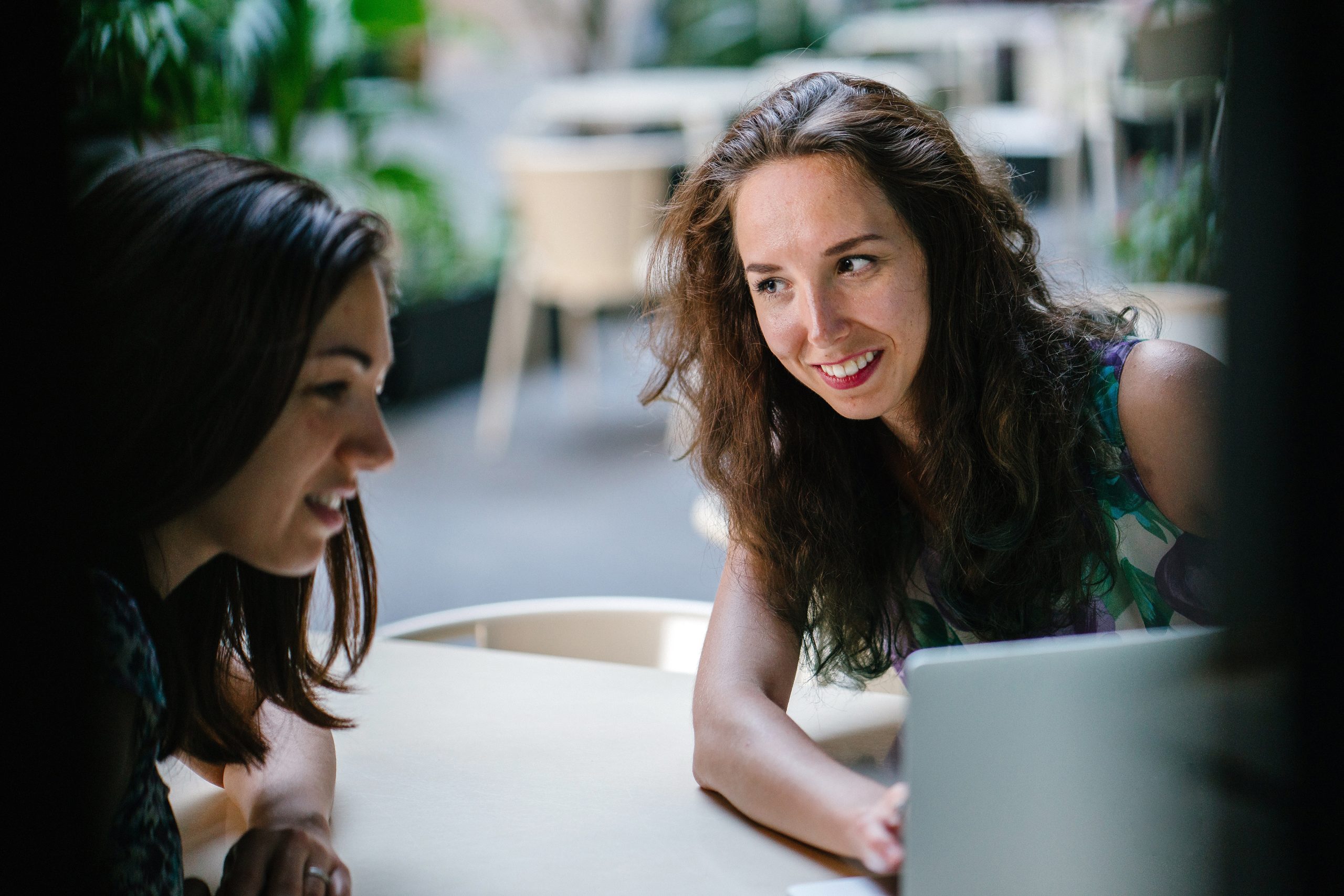 Two young women searching the internet for online resources geared towards herbalism and naturopathy. 