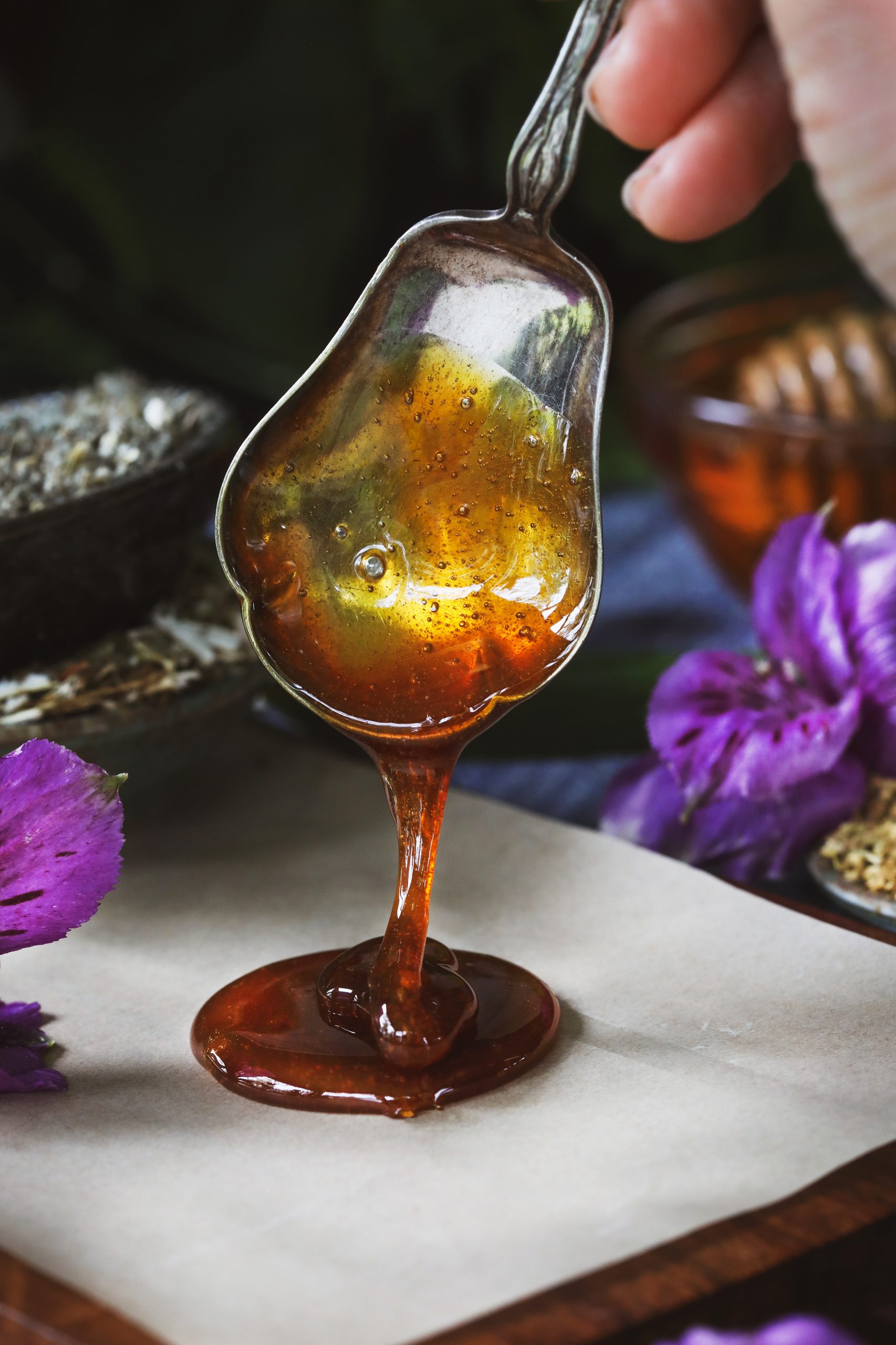 Lozenge syrup being dripped onto a piece of wax paper with a spoon