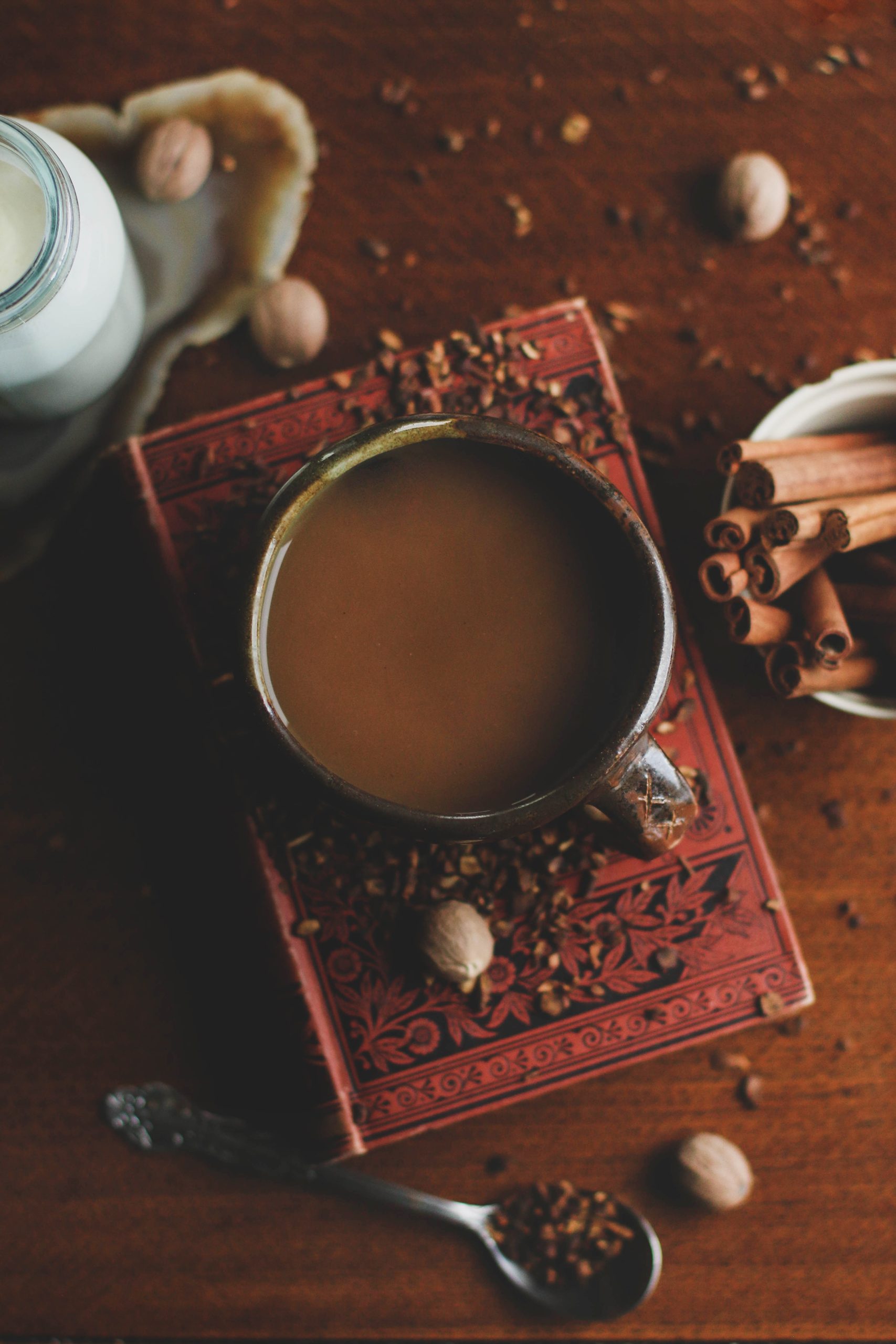 coffee cup with loose herbs strewn about and spoon