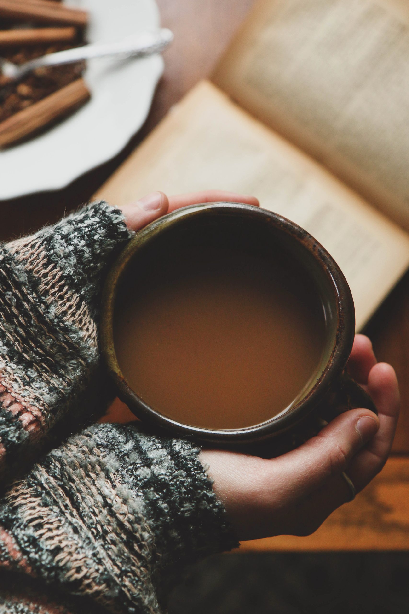 hands hold mug with warm beverage