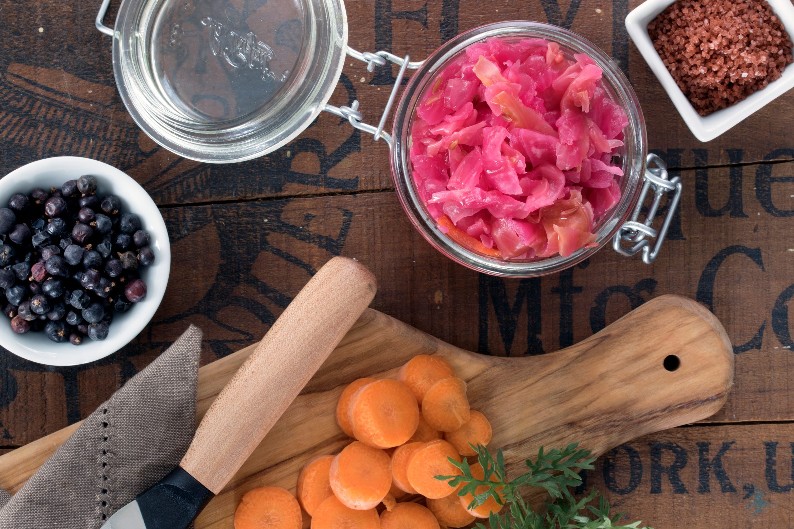 Ingredients for Red Alaea Sauerkraut including bowl of juniper berries and jar of colored cabbage Ingredients for Red Alaea Sauerkraut including bowl of juniper berries and jar of colored cabbage