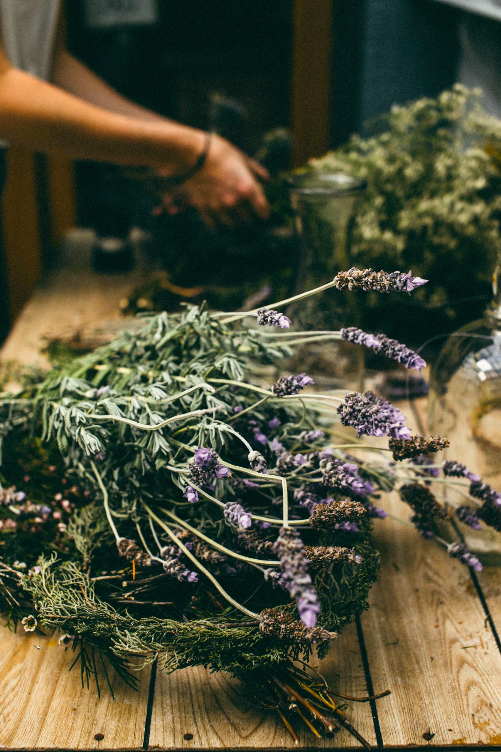 A bundle of dried lavender sits on a wooden table.