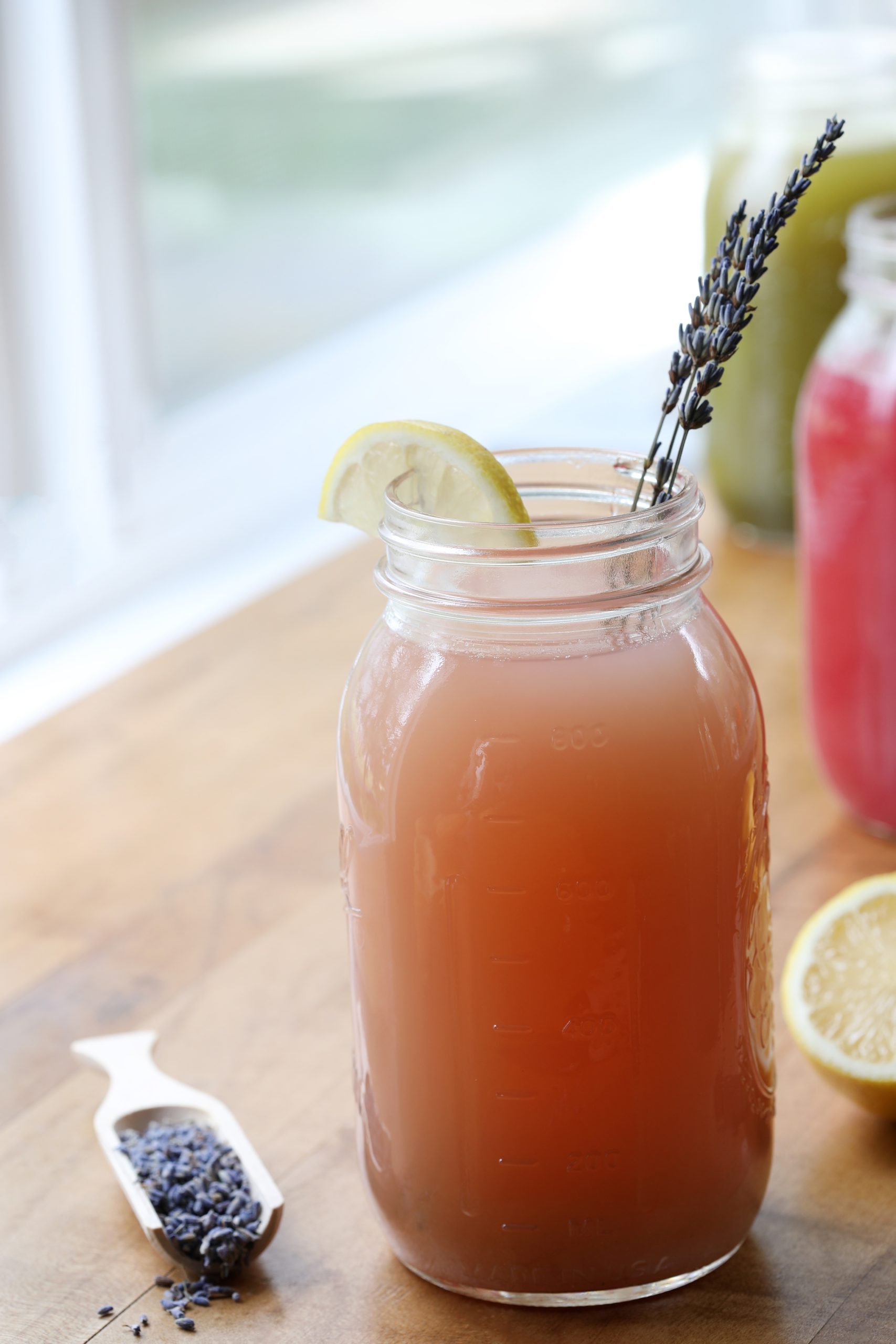 Mason jar of iced lemonade with lemon and lavender flowers sticking out