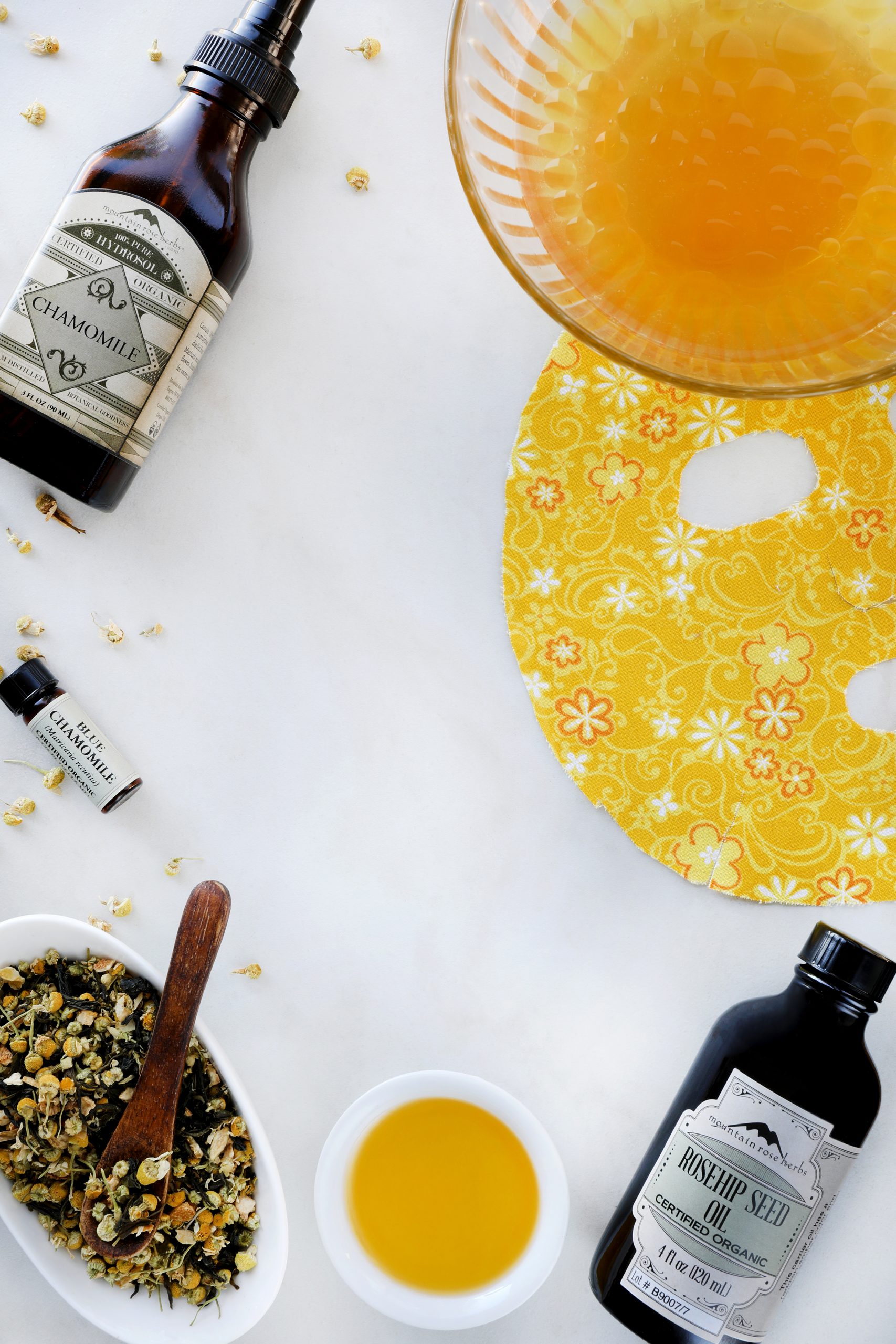 Rosehip seed oil, chamomile flowers, and chamomile hydrosol are blended to make a face mask serum for at home skin care.