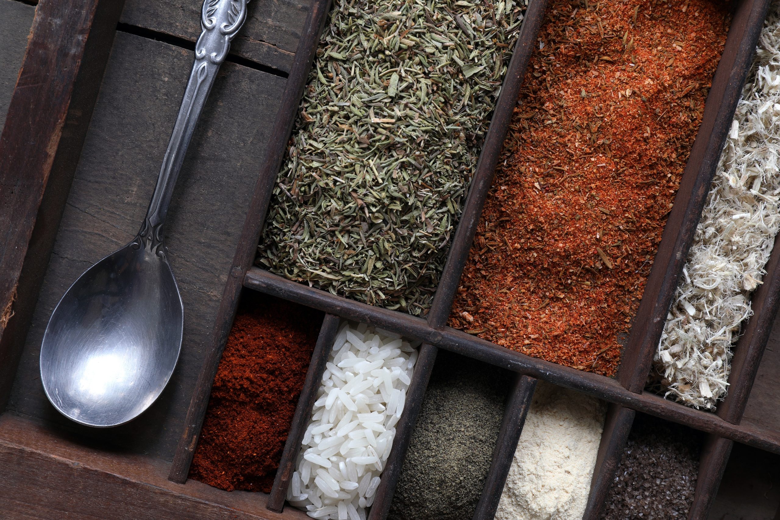 Spices and Ingredients used to make gumbo sitting in organizer with spoon Spices and Ingredients used to make gumbo sitting in organizer with spoon