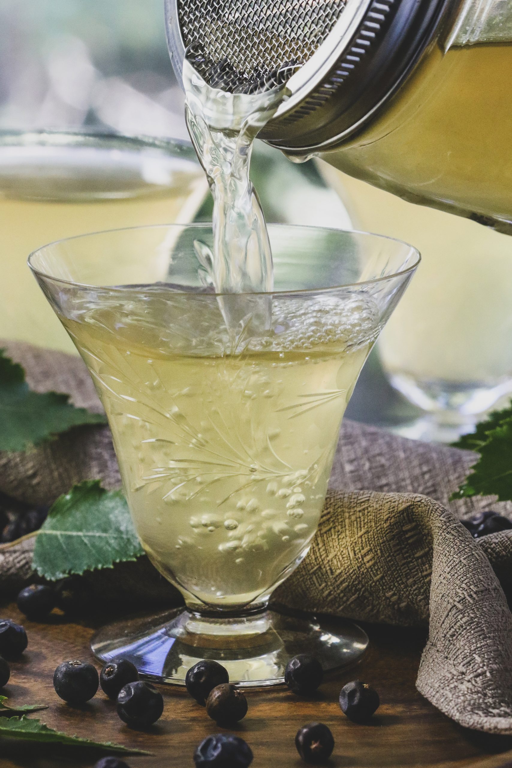 Golden beverage being poured into because glass. 