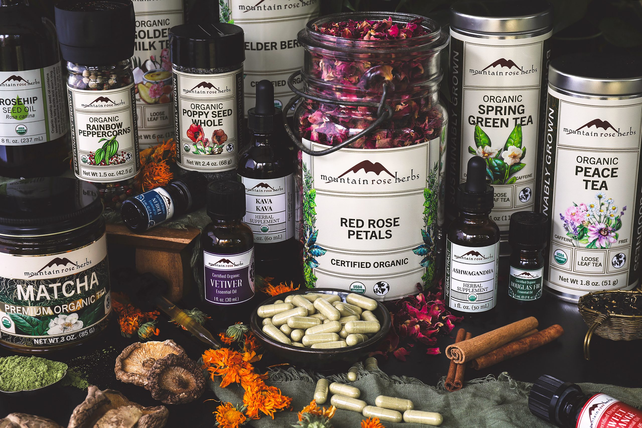 A selection of Mountain Rose Herbs products with loose herbs around them
