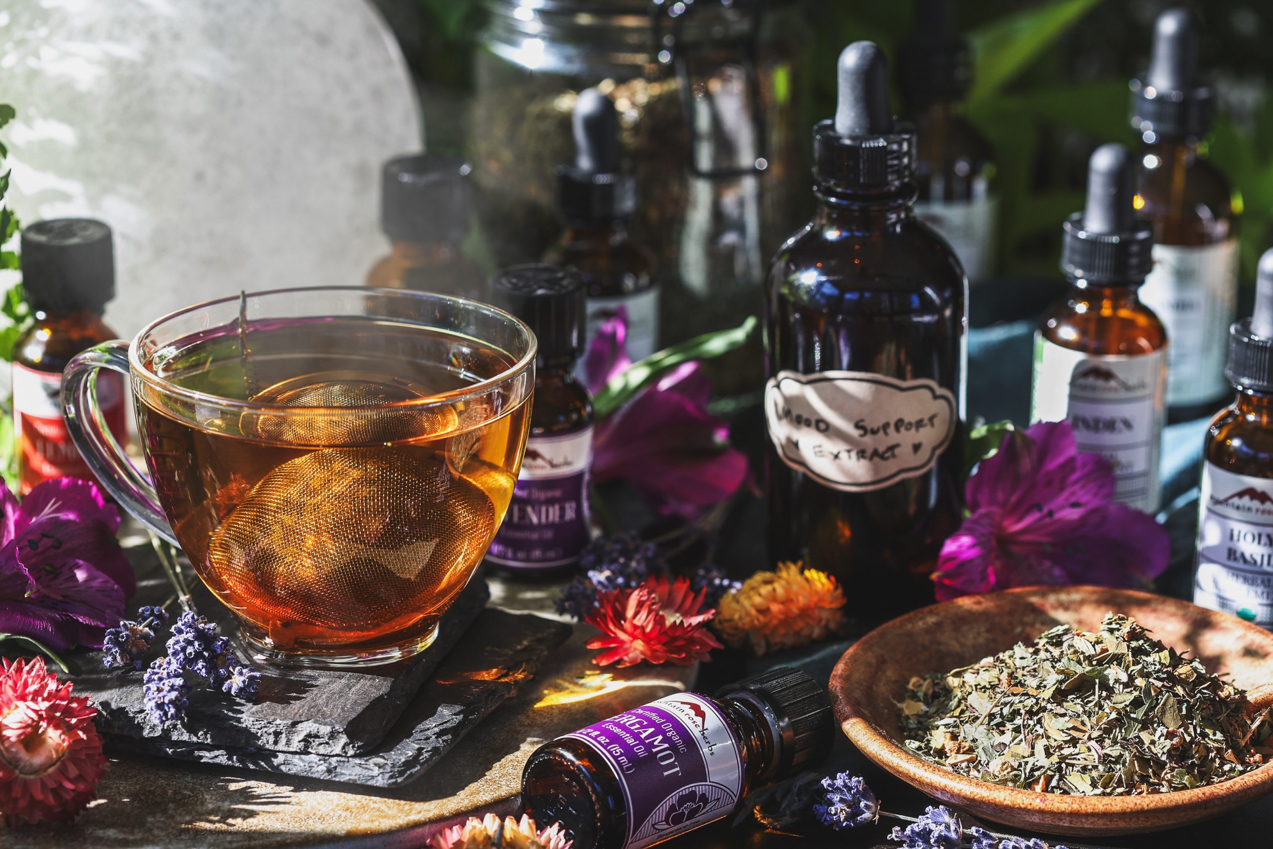 An assortment of herbal mood support recipes and a cup of freshly brewed tea