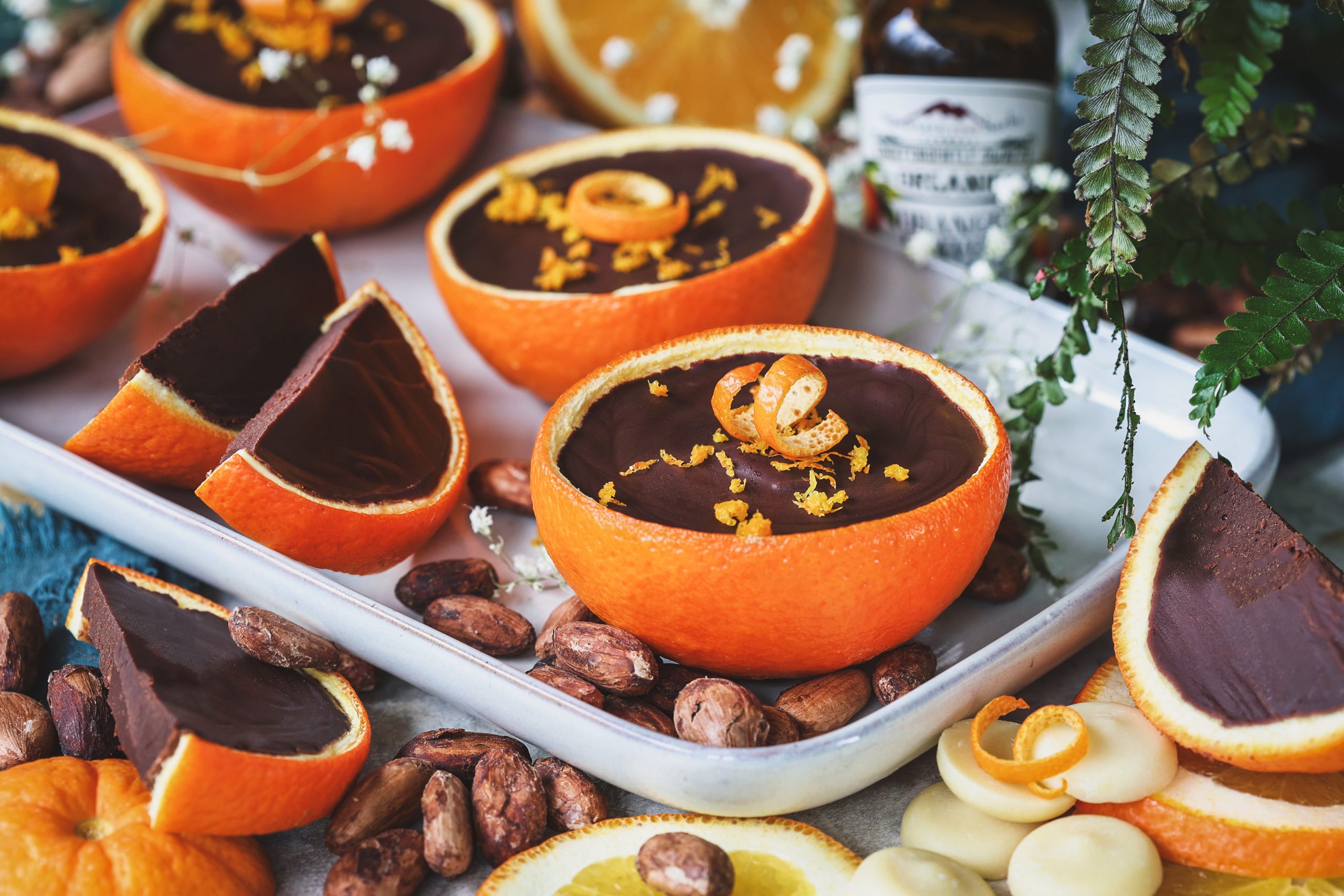 Chocolate orange cups on a serving tray with ingredients around them