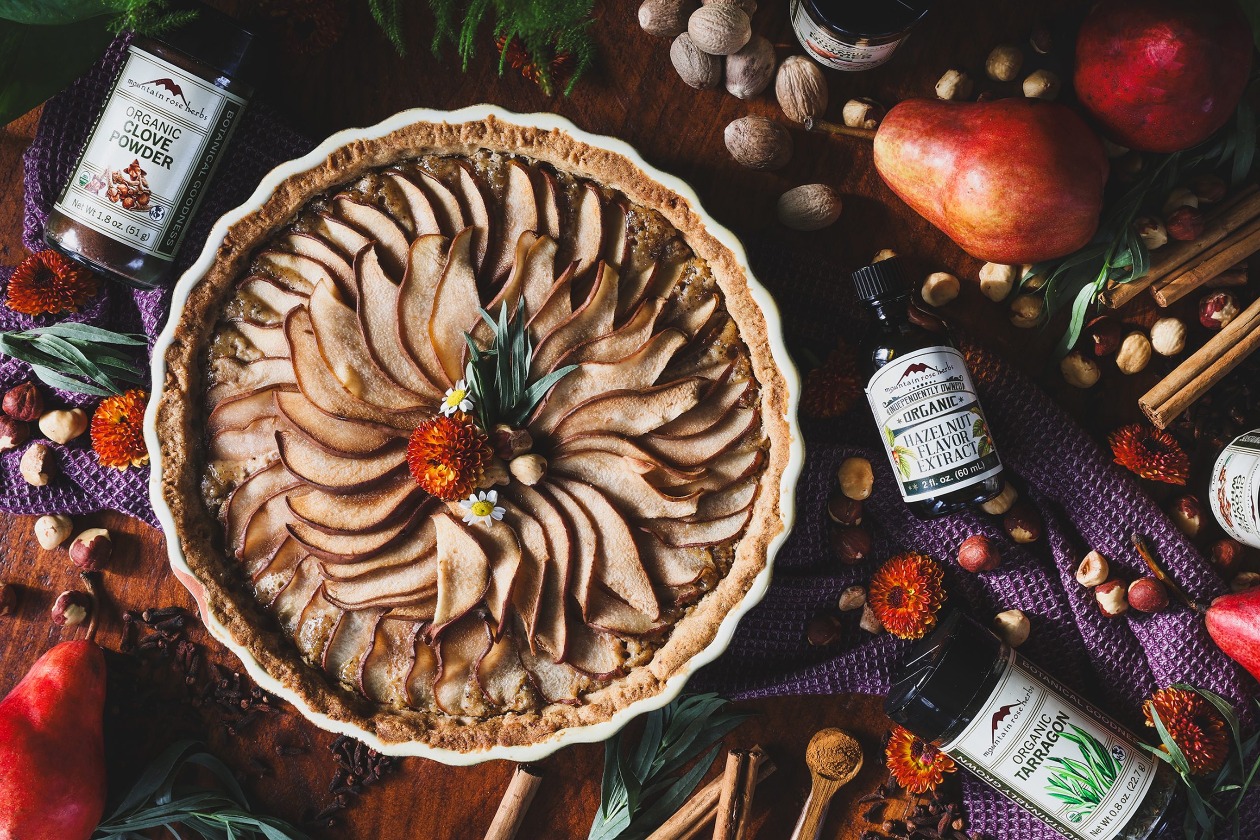 An overhead photo of hazelnut pear tart with ingredients around it