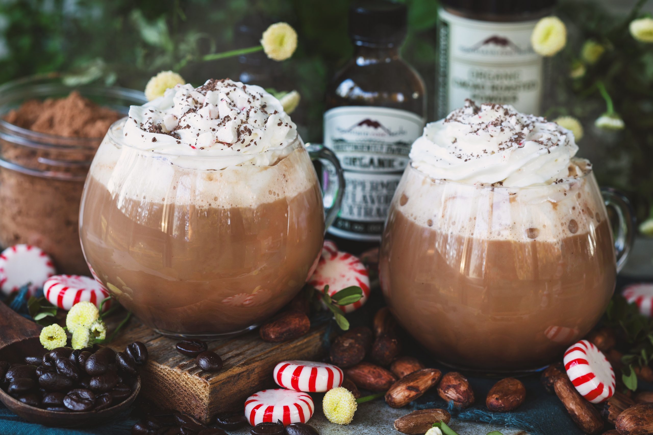 Two steamy mugs of peppermint mocha topped with whipped cream