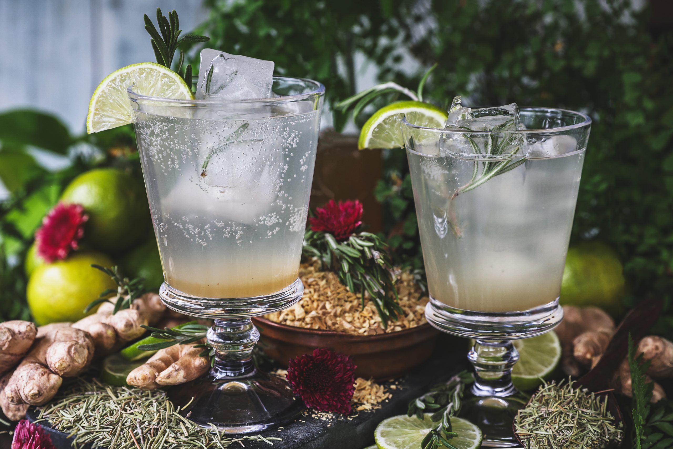 A horizontal photo of two rosemary mules with ingredients around them 