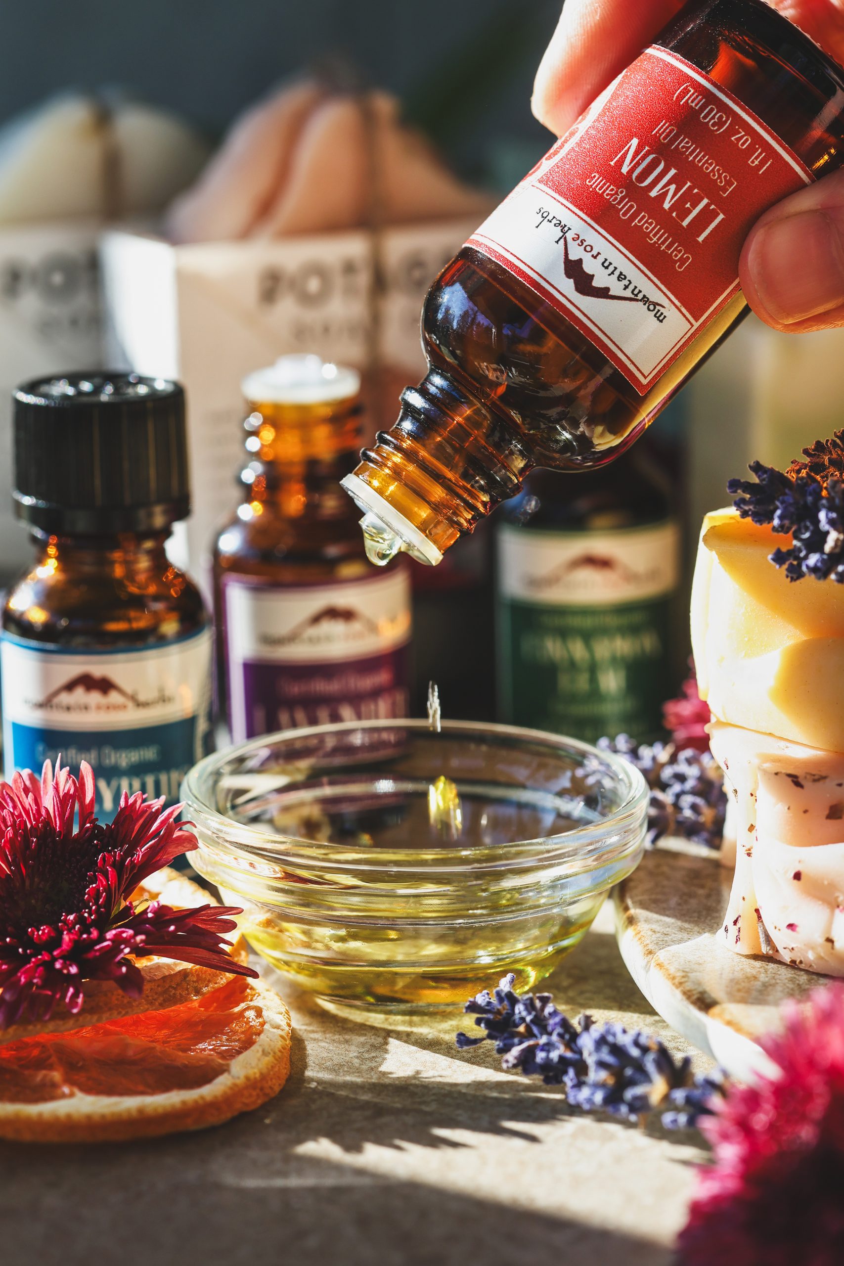 Lemon essential oil being dripped into a small glass blending bowl