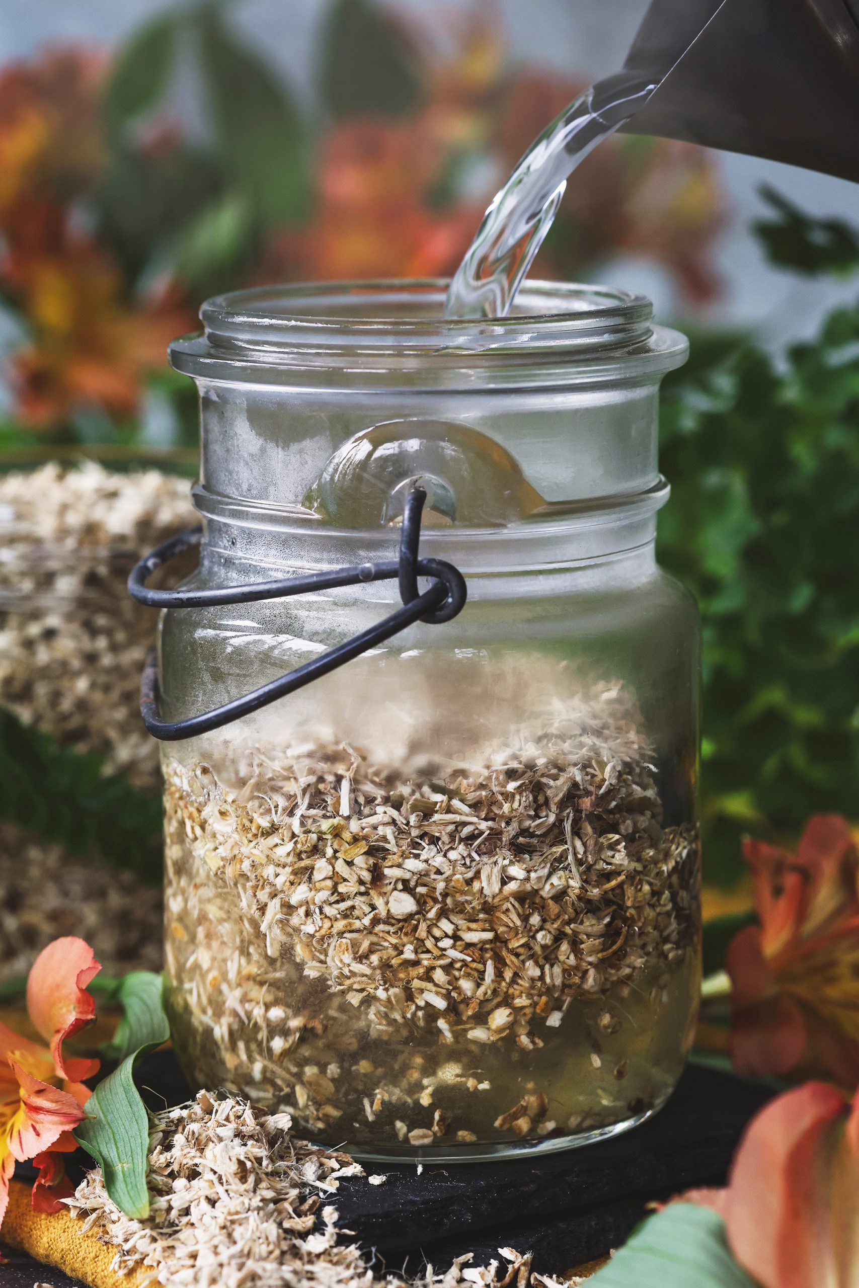 Hot water being poured into a jar with marshmallow root in it